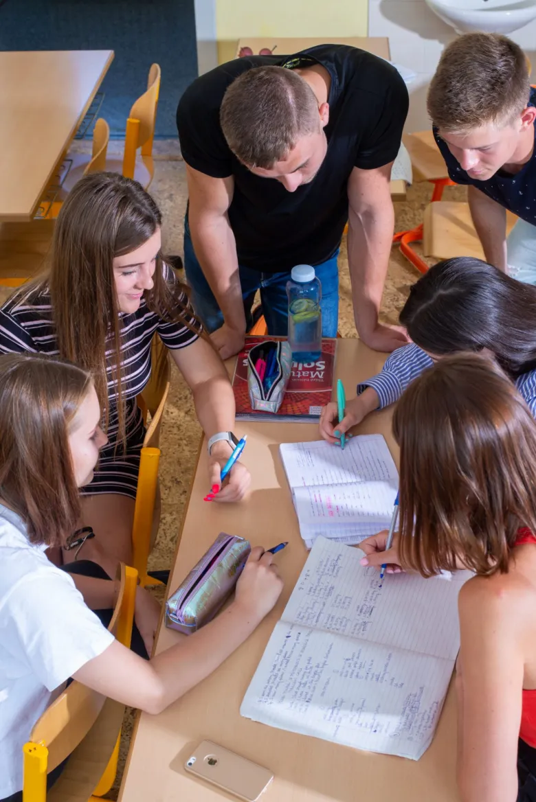 Skupina studentů se učí společně v jasně osvětlené třídě.