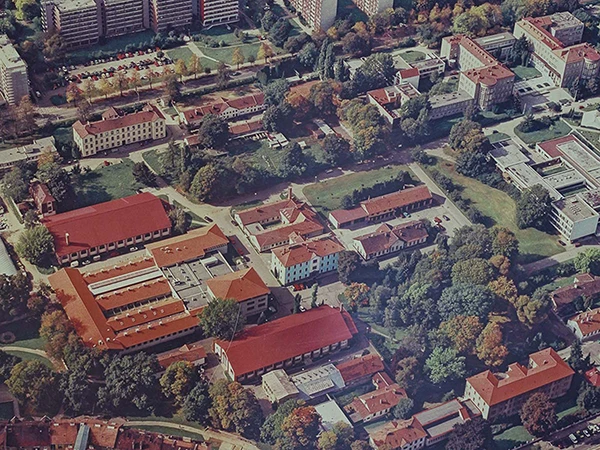 Vzdušný pohled na univerzitní kampus s budovami a zelení.