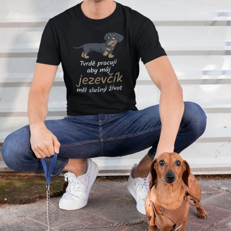 Muž sedící s jezevčíkem na vodítku venku.