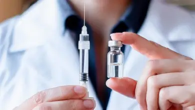 Lékař drží očkovací láhev a stříkačku pro obecný kontext.