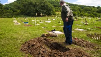Muž kopá hrob na pohřeb domácího mazlíčka.