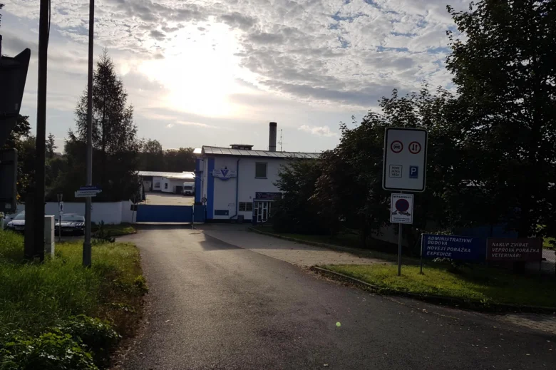 Výhled na administrativní budovu jatek s parkovištěm.