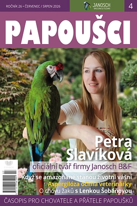 Žena drží zeleného papouška na paži před pozadím stromů.