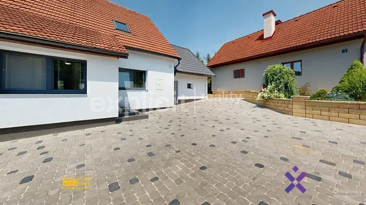 Dvůr mezi domy s dlažbou, bez slepic nebo plotu.